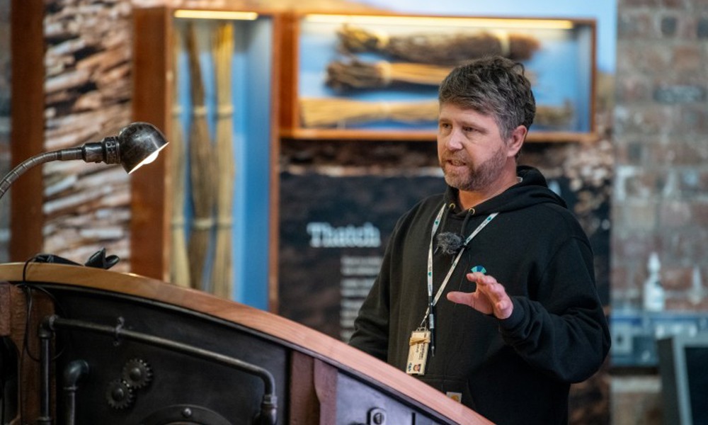 A person standing at a lectern giving a talk 