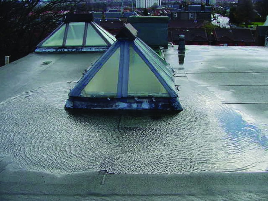 A puddle of water on top of a flat roof