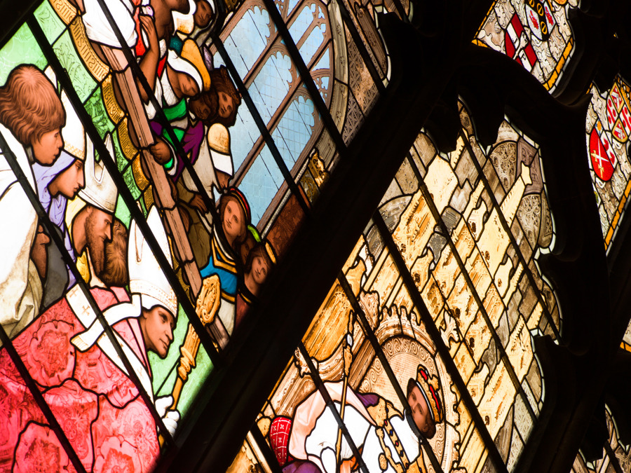 A huge, colourful stained glass window depicting religious scenes