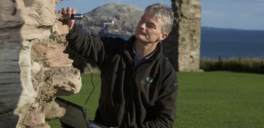 Someone scanning a historic stone structure