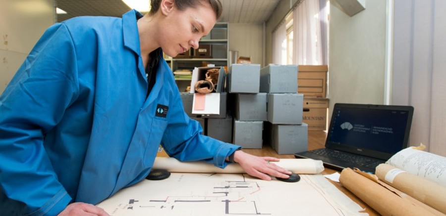 Someone looking through building plans on a desk