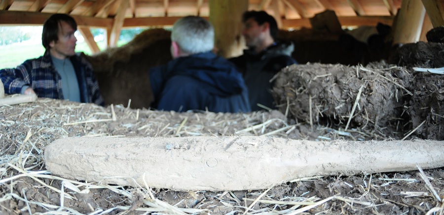 A pile of earth and people standing in the background