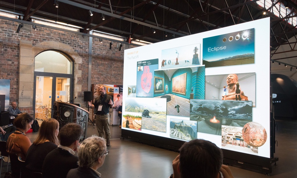 People sitting in front of a giant screen in the Engine Shed main space