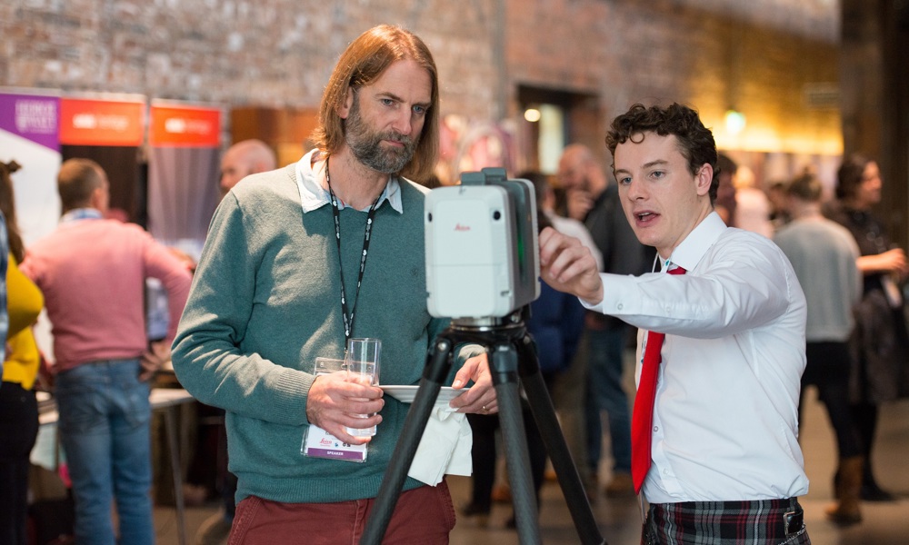Two people standing inside the Engine Shed looking at a laser scanner