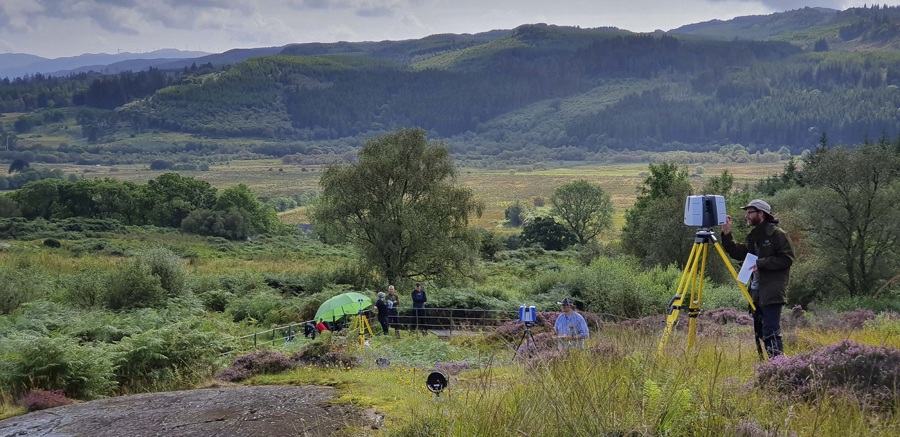 A person with a laser scanner in the countryside