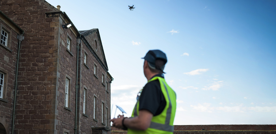 A person flying a drone over a historic building